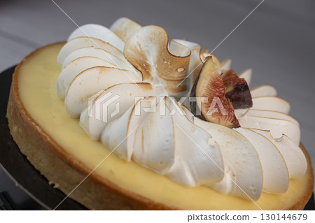Sunny and Bright Orange Lemon Citrus Meringue Pie on a black plate on white background 130144679