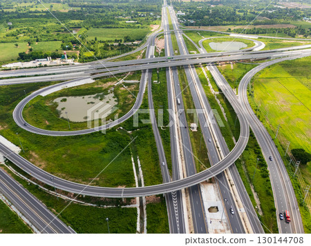 Drone shot a large highway interchange crossing over green farmlands in Thailand 130144708