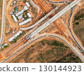The construction site before the construction of the concrete bridge over the intersection by crane workers, tractors, and backhoes 130144923