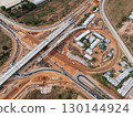The construction site before the construction of the concrete bridge over the intersection by crane workers, tractors, and backhoes 130144924