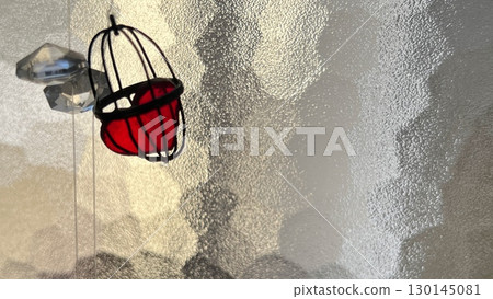 Glass window, glass wall, glass surface, red heart, glass heart, cage, bird cage, wirework 130145081