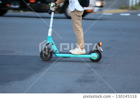 An electric kick scooter running on the road An electric kick scooter running on the road 130145318