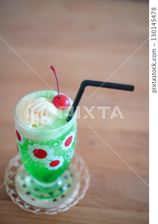 A nostalgic summer drink of melon soda float topped with cherries and ice cream A nostalgic summer drink of melon soda float topped with cherries and ice cream 130145478
