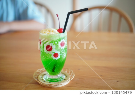 桌上擺放著復古甜瓜汽水漂浮物,配上冰淇淋和櫻桃 桌上擺放著復古甜瓜汽水漂浮物,配上冰淇淋和櫻桃 130145479