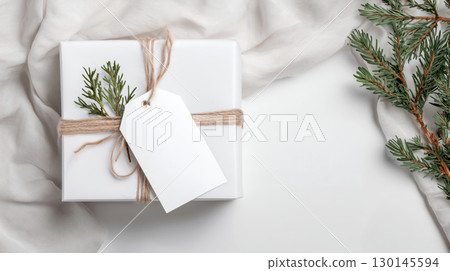 Christmas and New Year mockup of white gift box with blank tag on festive background and copy space, warm color tone. 130145594