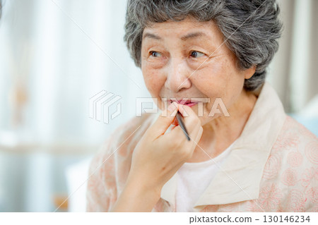 老年婦女在客廳塗口紅 130146234