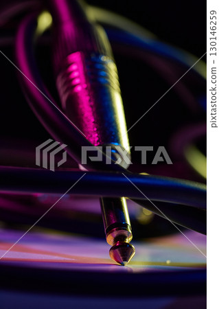 Close up of audio jack cable with neon lights retro music style Close up of audio jack cable with neon lights retro music style 130146259