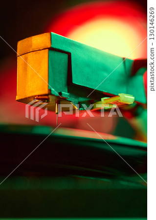Vinyl record stylus needle closeup with warm neon light 130146269