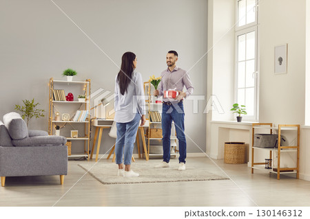 Husband Giving Wife Flowers And Gift On Valentine Day 130146312