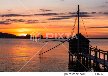 Evening view of Lake Togo: Sunset and a lookout hut for four-hand net fishing Evening view of Lake Togo: Sunset and a lookout hut for four-hand net fishing 130146375