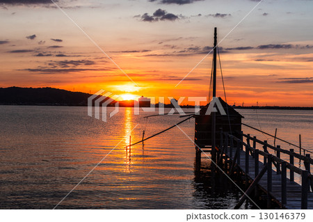 Evening view of Lake Togo: Sunset and a lookout hut for four-hand net fishing Evening view of Lake Togo: Sunset and a lookout hut for four-hand net fishing 130146379