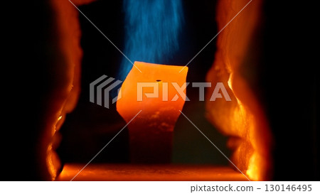 Hot steel close view in the steel plant forge. Detail of gas forge melting piece of iron. Black background. 130146495