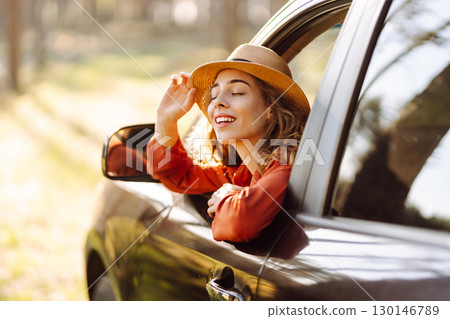 Young woman leaning out of the car window enjoying nature. Road trips summer holidays. Young woman leaning out of the car window enjoying nature. Road trips summer holidays. 130146789