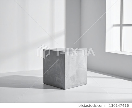 Gray Concrete Cube Centered in Minimalist White Room Near Window 130147416
