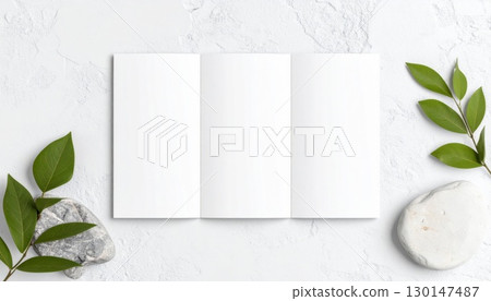 Elegant Trifold Brochure Mockup Featuring Decorative Green Leaves and Smooth Stones on White Textured Surface 130147487