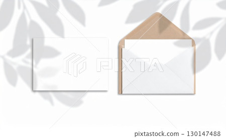 Elegant Kraft Envelope with Blank Card Mockup with Leaf Shadow Overlay on White Background 130147488