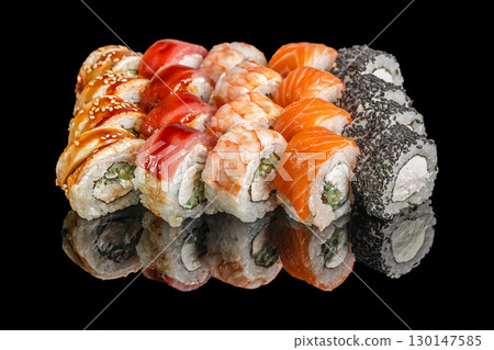 Assorted sushi rolls with salmon, tuna, shrimp, and sesame on black background 130147585