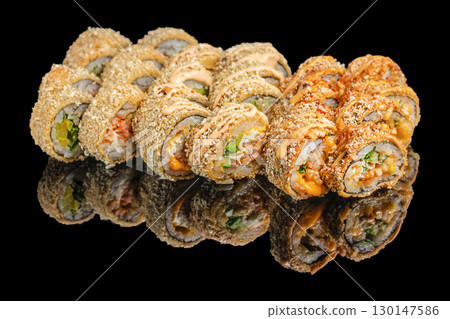Crispy deep fried sushi rolls with sauce on black background 130147586