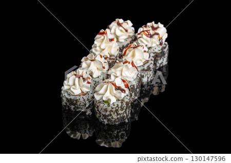 Sushi rolls topped with cream cheese and sauce on black background Sushi rolls topped with cream cheese and sauce on black background 130147596