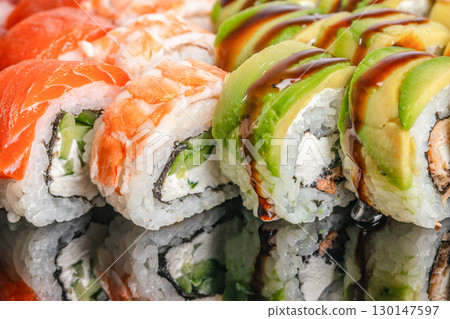 Close-up of assorted sushi rolls with avocado, cream cheese and sauce 130147597