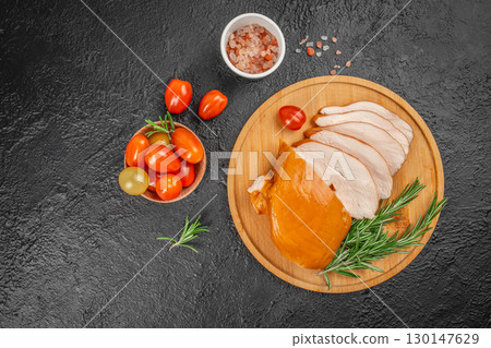 Smoked chicken breast slices with cherry tomatoes and rosemary on dark background. top view. copy space 130147629