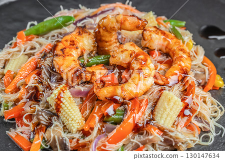 Stir fried rice noodles with shrimp and vegetables served on a plate Stir fried rice noodles with shrimp and vegetables served on a plate 130147634