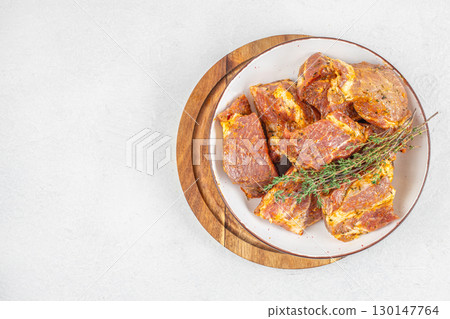 Raw marinated pork ribs with spices and herbs on white plate. top view. copy space 130147764