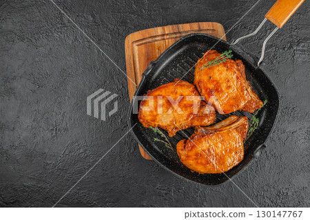 Grilled pork chops with herbs on a black grill pan. top view. copy space 130147767