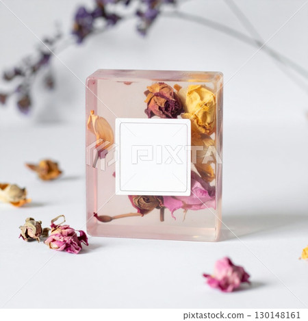 Artisanal Soap Embedded with Dried Roses on White Surface with Subtle Background Flowers 130148161