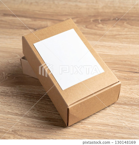 Simple Brown Cardboard Box with White Label on Light Brown Wooden Surface Simple Brown Cardboard Box with White Label on Light Brown Wooden Surface 130148169