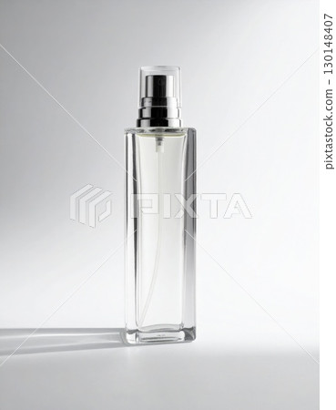 Elegant Clear Glass Perfume Bottle with Silver Sprayer on a White Surface Elegant Clear Glass Perfume Bottle with Silver Sprayer on a White Surface 130148407