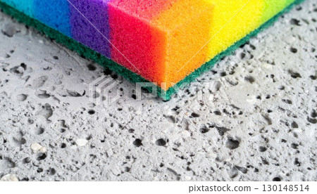 Detailed Close Up of Rainbow Colored Sponge on Textured Gray Surface Macro Shot 130148514