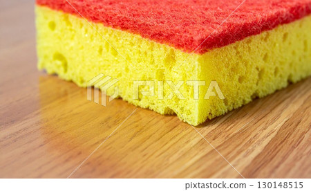Close Up of Yellow and Red Sponge on Wooden Surface for Cleaning and Household Work 130148515