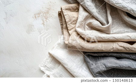Folded Natural Linen Fabric Stack with Rough Texture in Beige Gray and White Color on Rustic Surface Folded Natural Linen Fabric Stack with Rough Texture in Beige Gray and White Color on Rustic Surface 130148613
