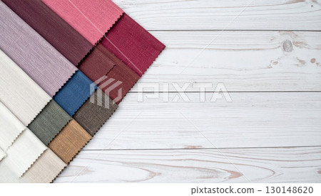 Arrangement of Varied Colored Fabric Swatches on a White Wooden Surface Provides Abundant Background Texture Arrangement of Varied Colored Fabric Swatches on a White Wooden Surface Provides Abundant Background Texture 130148620