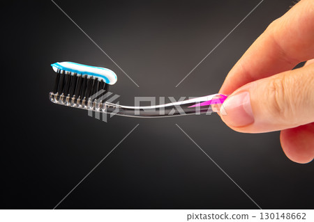 toothbrush with toothpaste for cleaning teeth on a dark background. health care toothbrush with toothpaste for cleaning teeth on a dark background. health care 130148662