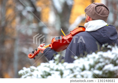 Street musician playing the violin. Musical creativity. Bowed stringed musical instrument 130148681