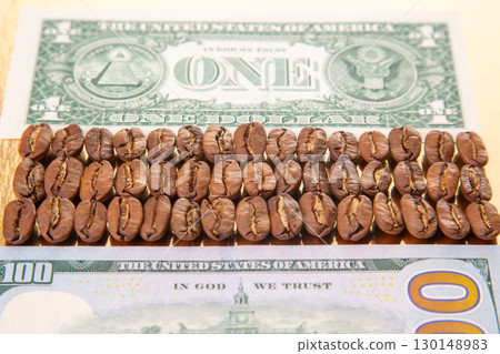 Close-up of a U.S. dollar bill topped with coffee beans, featuring detailed currency 130148983