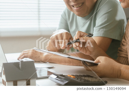 senior couple and documents with laptop for finance, budget planning or retirement annuity on sofa. Elderly man, woman or house with smile, computer or paperwork for pension fund or insurance senior couple and documents with laptop for finance, budget planning or retirement annuity on sofa. Elderly man, woman or house with smile, computer or paperwork for pension fund or insurance 130149094