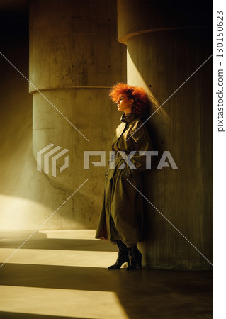 A woman with red hair stands in front of a pillar 130150623