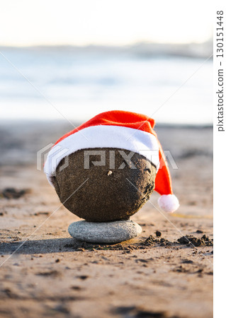 Christmas sand sculpture with Santa hat on the beach Christmas sand sculpture with Santa hat on the beach 130151448