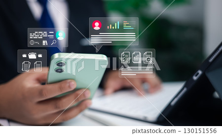 Businessman using smartphone and tablet with digital data analytics, online communication, and document management icons overlay for business technology concept 130151556