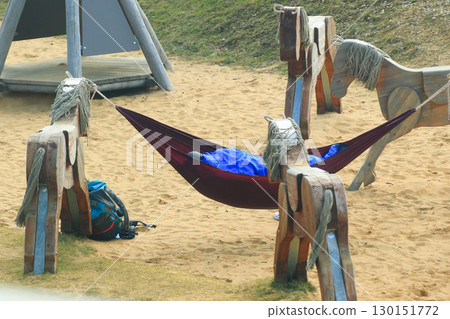 Relaxing Alone In Hammock Among Wooden Playground Horses Relaxing Alone In Hammock Among Wooden Playground Horses 130151772