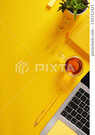 Vertical banner with office supplies and a laptop. Yellow background, space for your text. 130152425