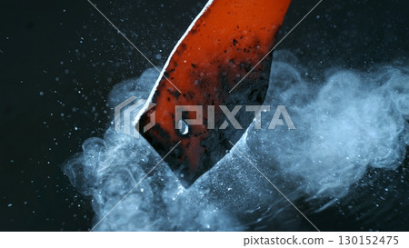 Blacksmith puts the red-hot forged metal part into cold water , close-up 130152475