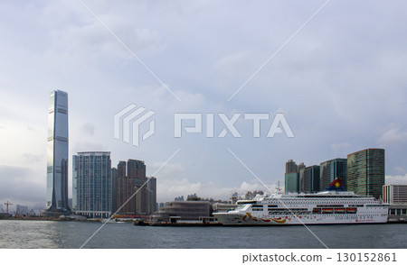 View Of Skyscrapers And Apartment Buildings With Cruise Ship Docked At Tsim Sha Tsui Harbour, Hong Kong. 130152861