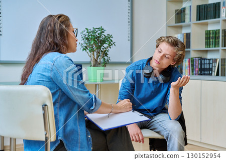 Teenage student guy with school counselor, coach in meeting room 130152954