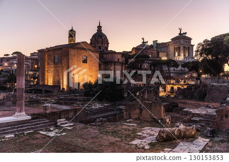 Ancient Roman Forum ruins and illuminated historical buildings at sunset in Rome, Italy 130153853