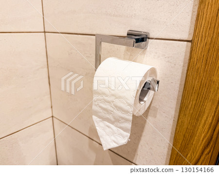 Toilet paper roll on holder. Hygiene, cleanliness, and daily household essentials. 130154166