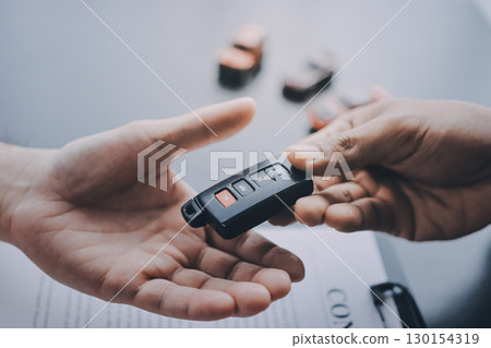 Car salesman gave the keys to the customers who signed the purchase contract legally, Successful completion of car sales, Purchase contract and key delivery. 130154319